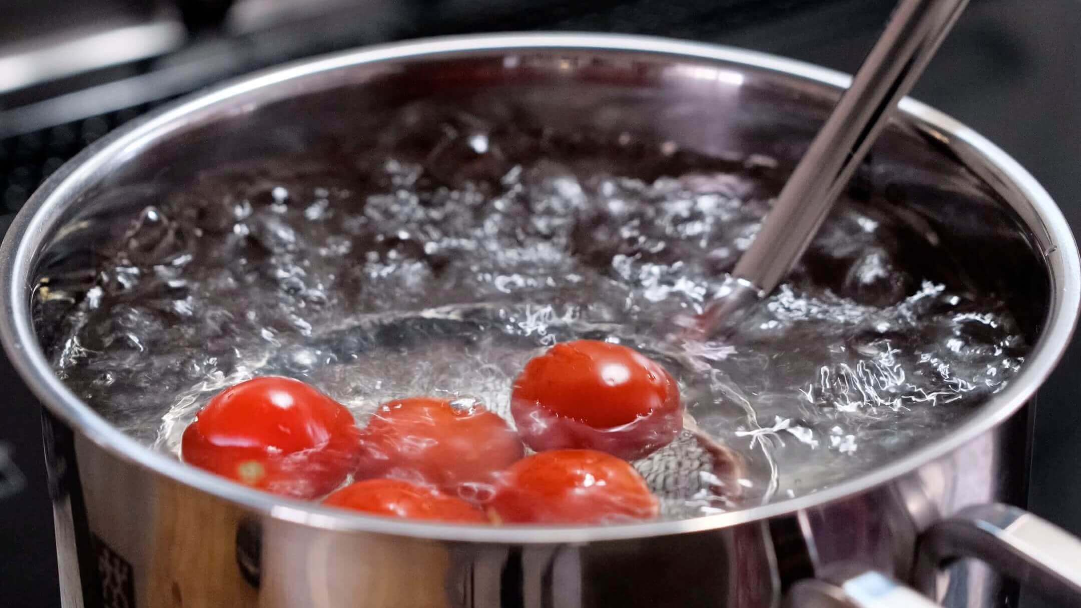 トマトを熱湯に入れている